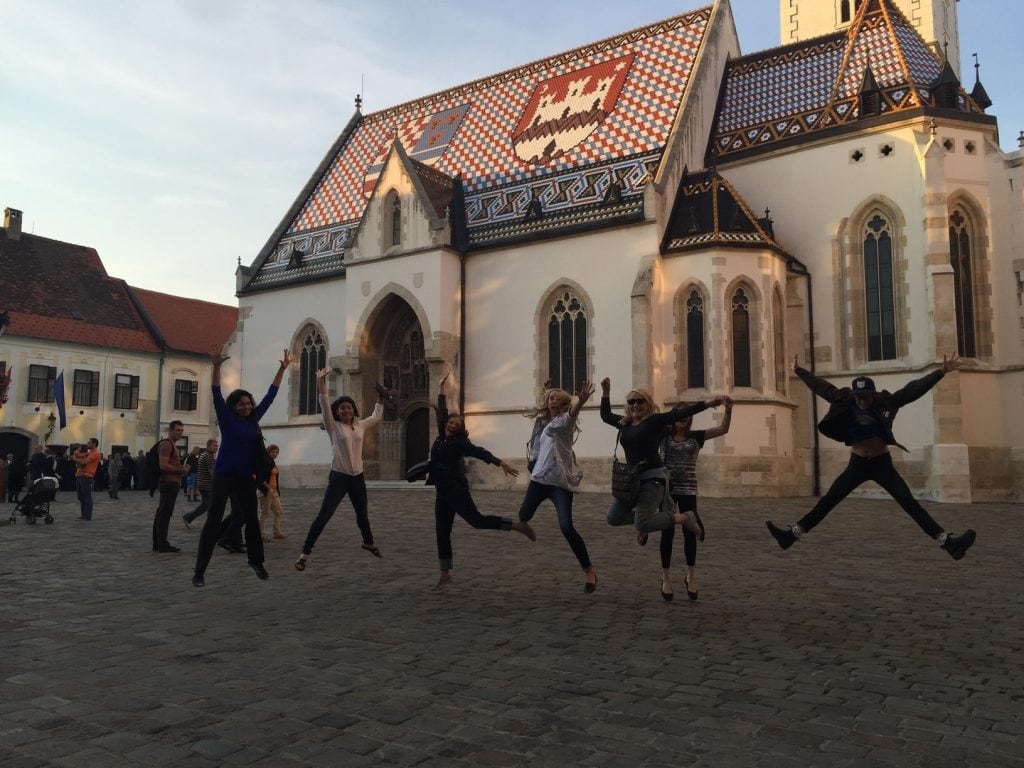Women Dancing in Plaza in front of European church